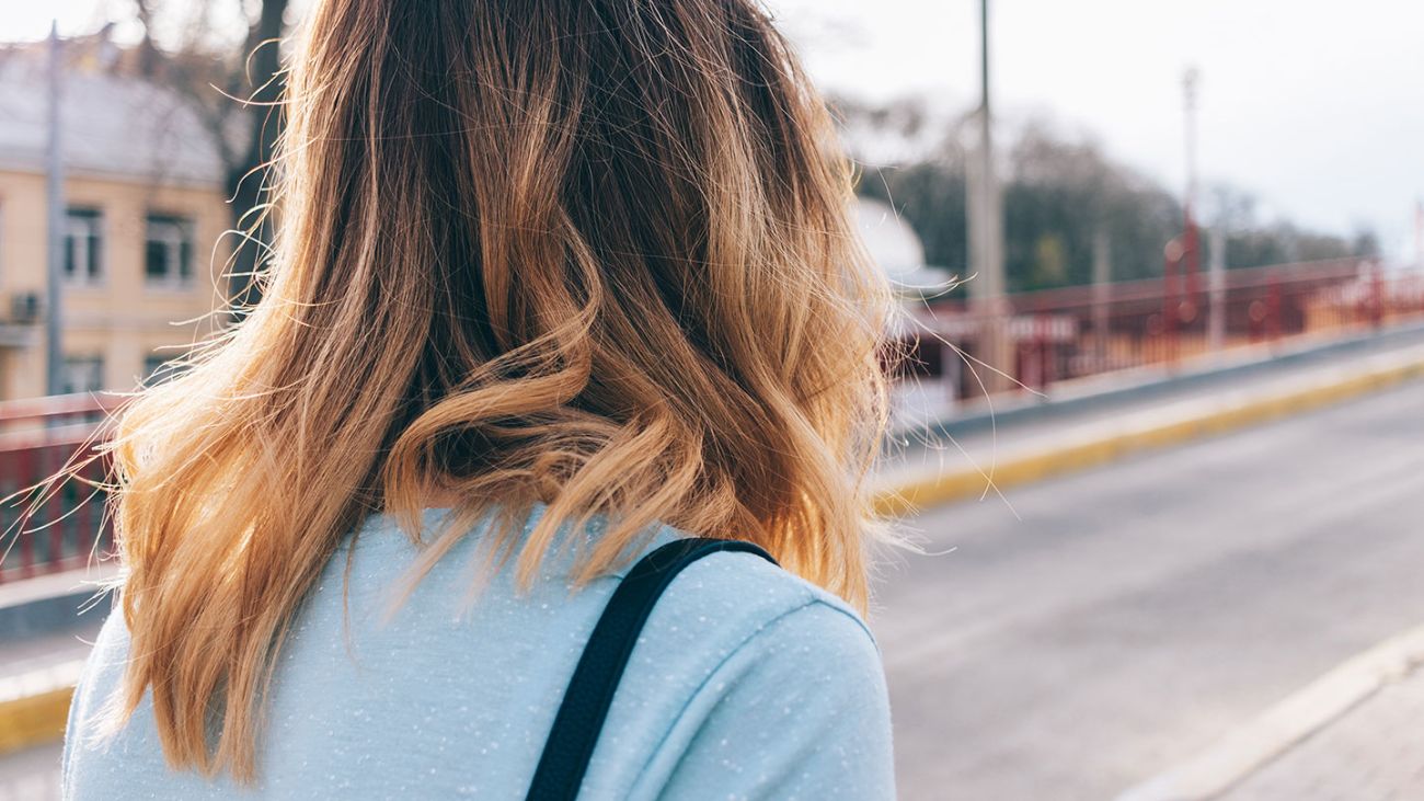 The back of a woman's head, focused on her healthy hair.