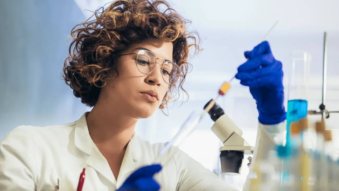 A scientist focusing on a tool in her lab.